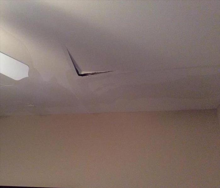 visible water damage to ceiling, fan blade visible