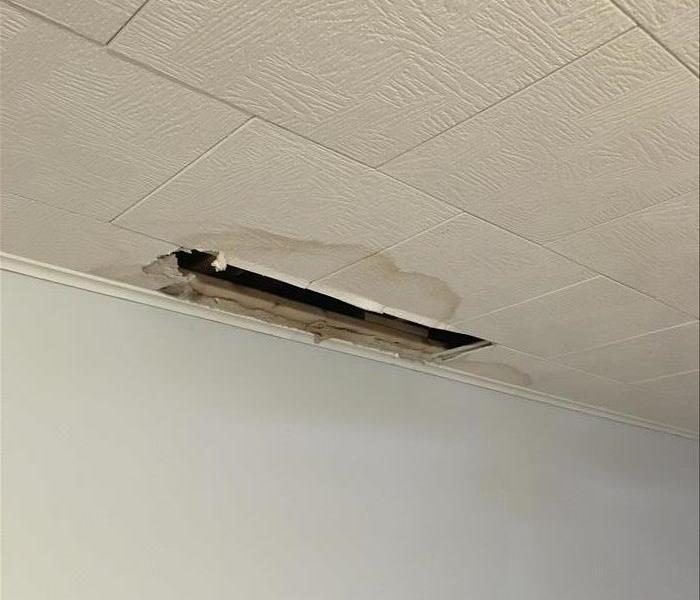 stained water damaged ceiling, hole by wall