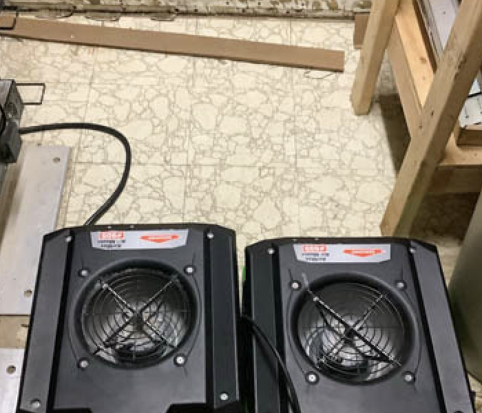 Two SERVPRO air movers drying water damaged flooring